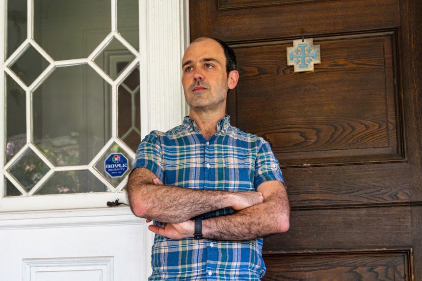 Man in plaid shirt sues ICE over agents' visit after critical email.
