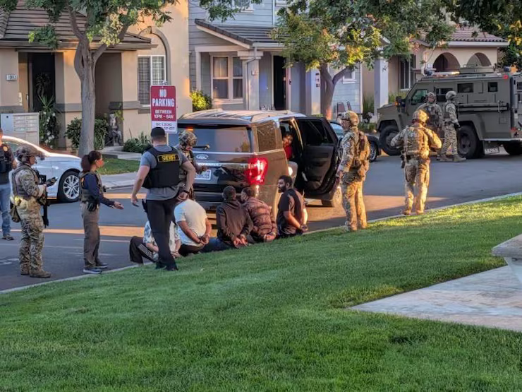 Law enforcement arrests men in suburban setting, related to visa and immigration.