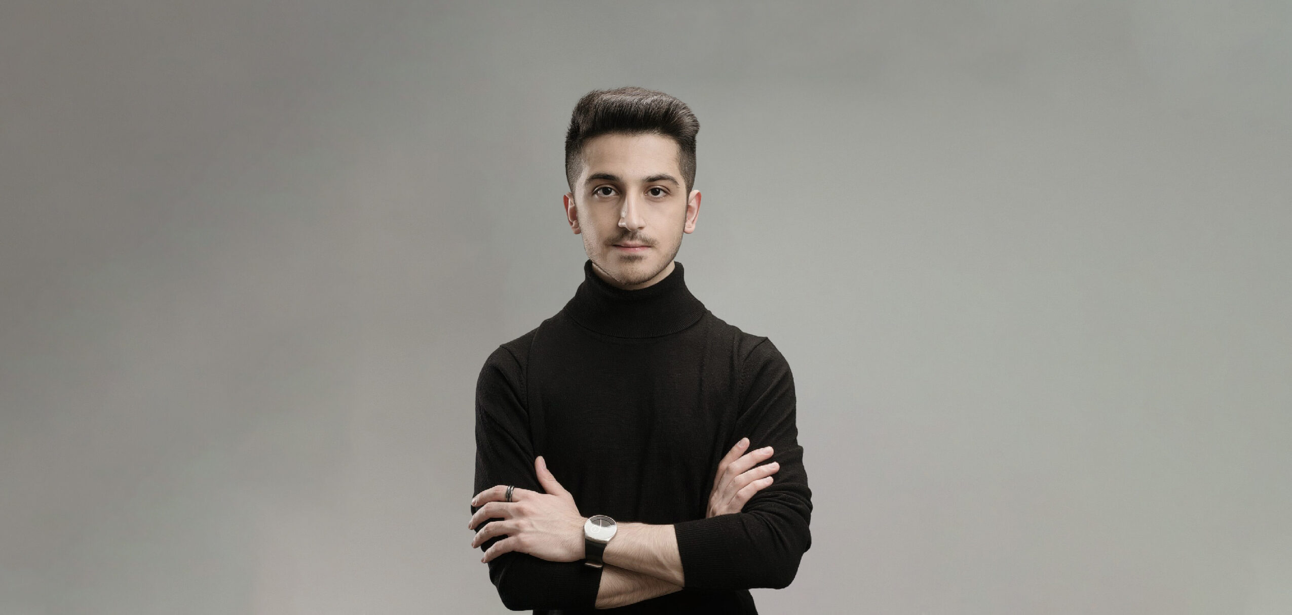 Kuwaiti artist with arms crossed, relevant to visa and immigration discussion.
