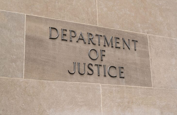 Department of Justice sign on a building, relevant to education and student lawsuits.