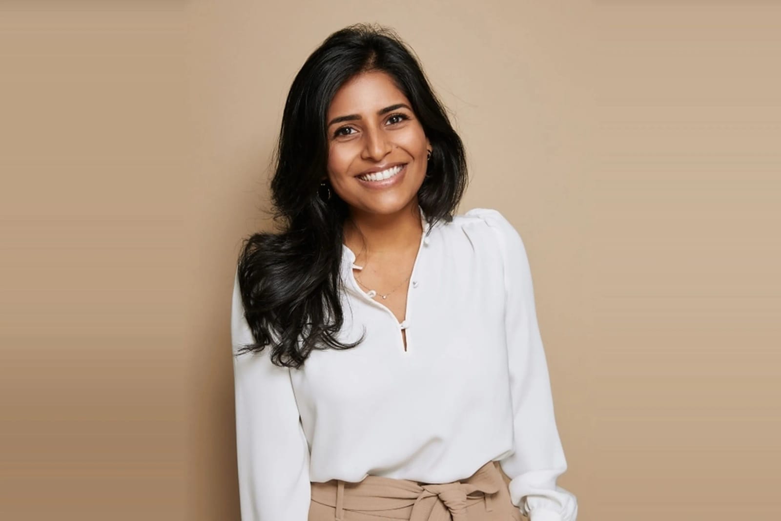 Indian American tech founder smiles confidently, representing AI health startup success.