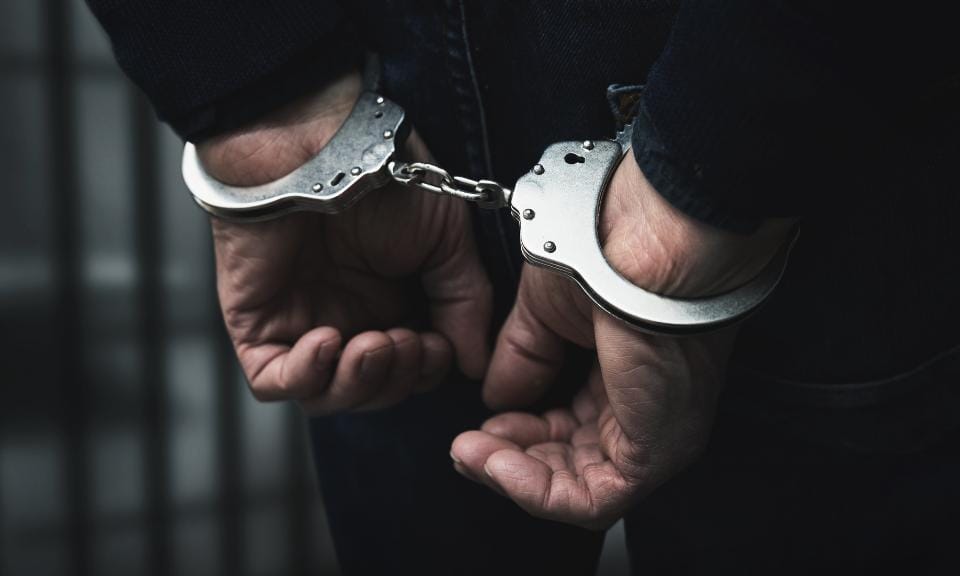 Handcuffed hands, symbolizing arrest in a news report about an ex-CFO.