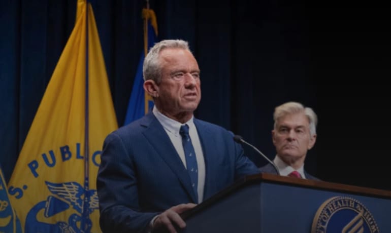RFK Jr. speaks at podium, halting $1B Medicaid payments due to fraud claims.
