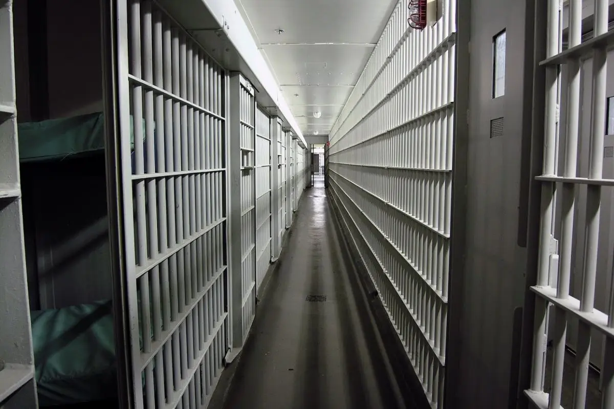 Prison hallway with cells, relevant to New Jersey pharmacy fraud case.