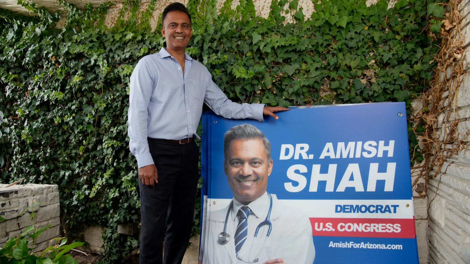 Dr. Amish Shah, Democrat for U.S. Congress, poses next to his campaign sign.