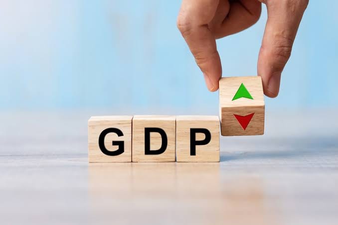 Wooden blocks spelling "GDP" with an upward arrow on the last block.