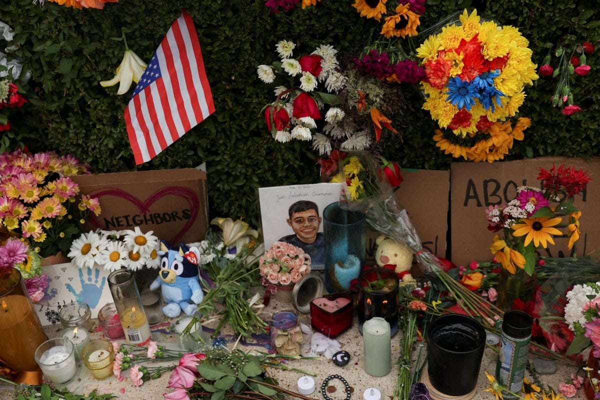 Memorial with flowers, US flag, and child's portrait.