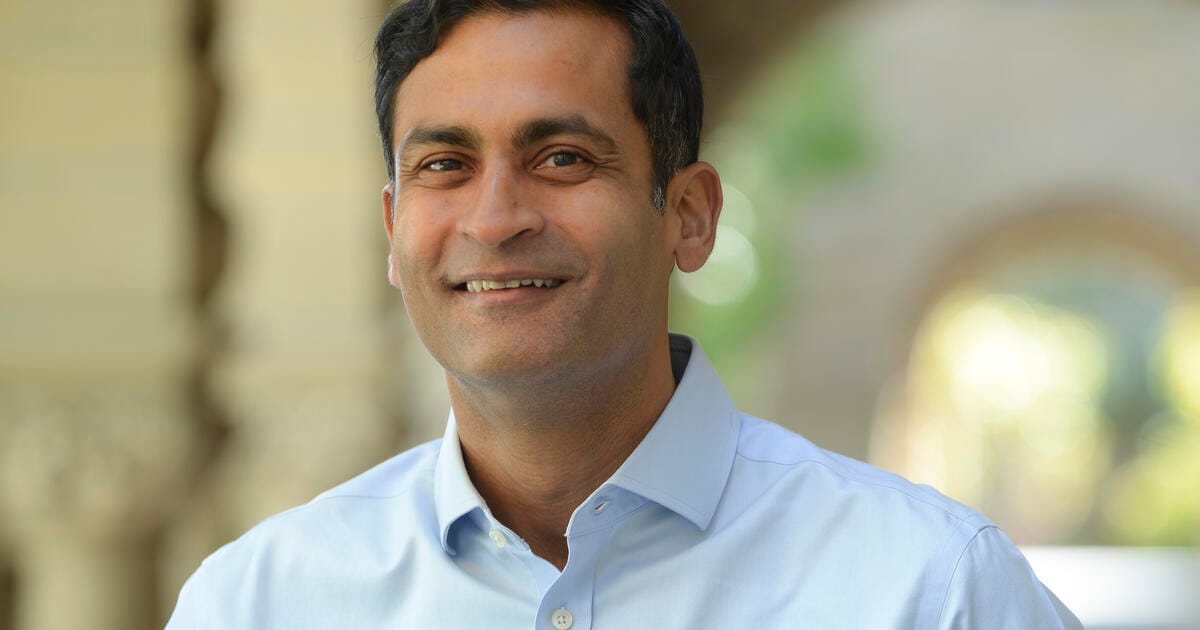 Indian American Professor Saumitra Jha, Falling Walls finalist, smiles for news photo.