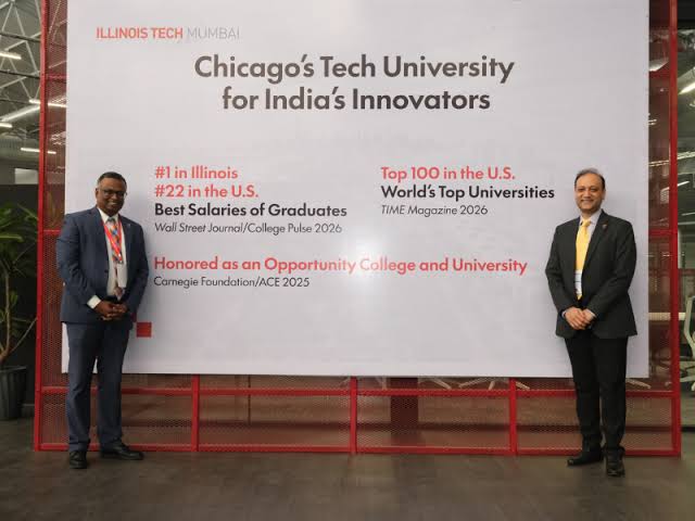 Illinois Tech Mumbai leaders pose before a banner celebrating the tech university's achievements.